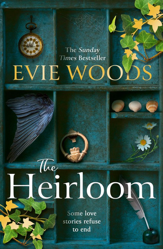 Livre 'The Heirloom' par Evie Woods. Couverture représentant une vieille porte avec des compartiments. Contient une montre de poche, une aile de corbeau, des coquillages, un heurtoir trèfle, des fleurs et des plumes.