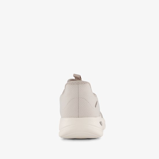 Achterkant van een beige sneaker met crèmekleurige zool en lus.