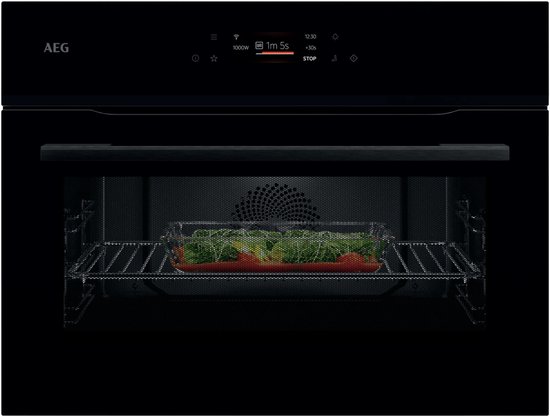 Zwarte AEG compacte combi-oven met magnetronfunctie, glazen schaal met groenten en tomaten op rooster, TFT-touchscreen met '1m 5s STOP'.
