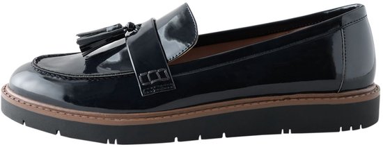 Zwarte lakleren loafer met dikke zool en kwastjes, geïsoleerd op een witte achtergrond.
