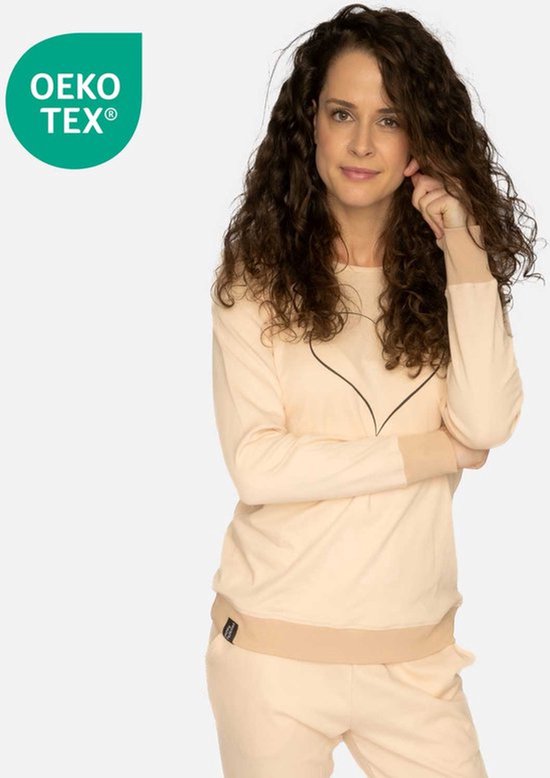 Model draagt een lichtroze pyjamashirt met een zwart hart op de borst. Links op de borst een Oeko-Tex label.