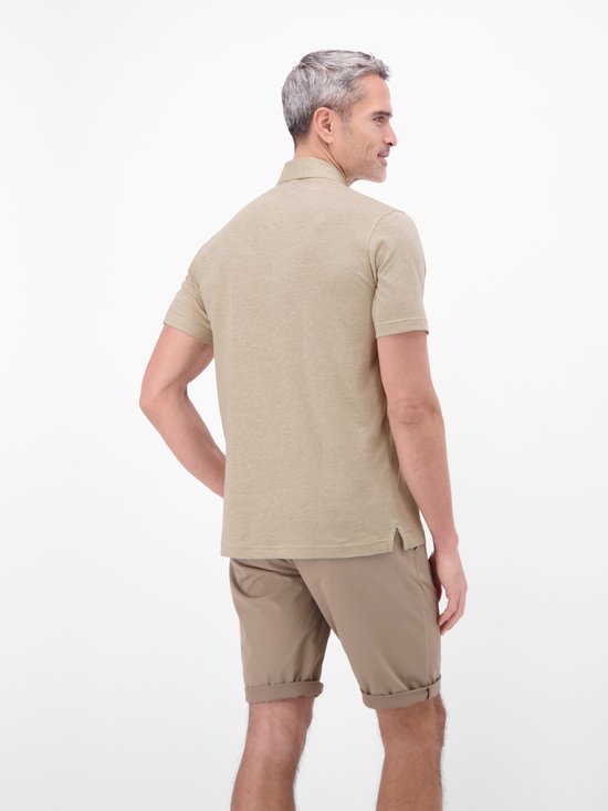 Man met hand in de zak, in een lichtbruin gemêleerd poloshirt en een beige short.