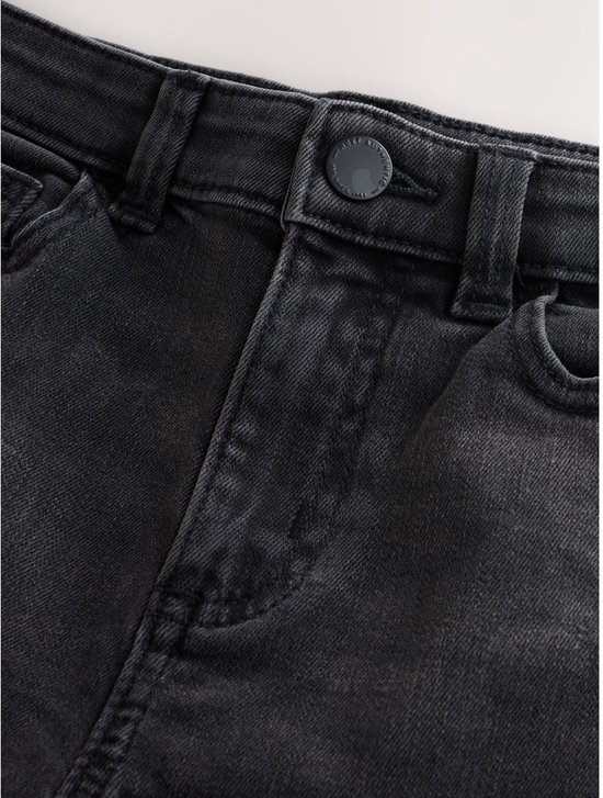 Detail van de tailleband van een zwarte spijkerbroek met knoopsluiting en verstelbare tailleband.