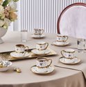 Set van 6 porseleinen Turkse koffiekopjes en schotels met bloemenpatroon en goudkleurige rand op tafel.