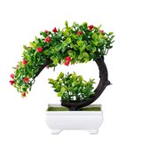Kunstbonsaiboom met groene bladeren en rode bloemen in een witte pot, geïsoleerd op wit.