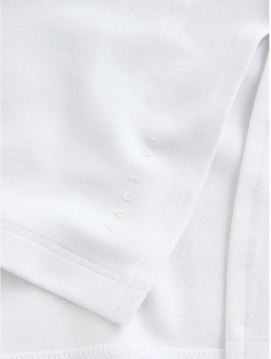 Detailopname van de zoom van een wit katoenen T-shirt met ingeweven tekst.
