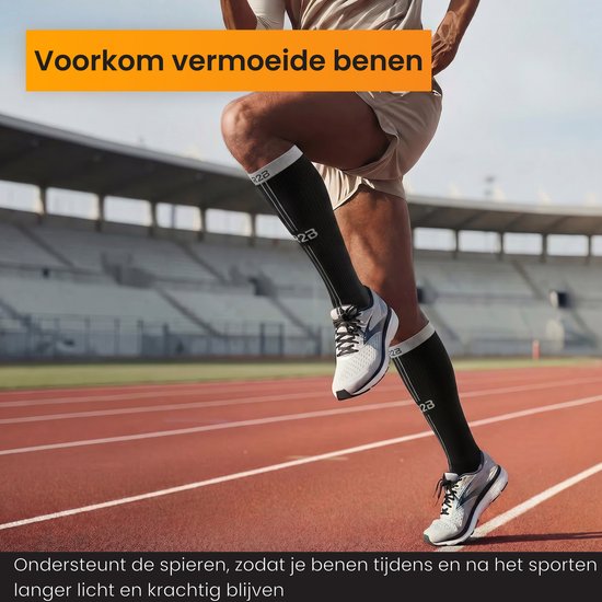 Man op een atletiekbaan die rent in zwarte compressiekousen met 'R2B' logo en witte strepen.