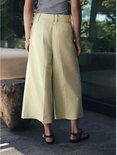 Achterkant van het model in lichtgroene culotte met een grijze top.