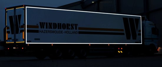 Witte vrachtwagenaanhanger met reflecterende contourmarkering en de tekst 'WINDHORST HAZERSWOUDE-HOLLAND'.