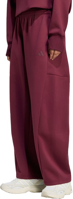 Bordeauxrode, wijde sportbroek met elastische tailleband en Adidas logo op de linker heup.