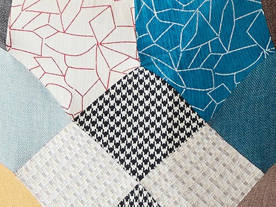 Detail van patchwork stof met patronen zoals pied-de-poule, lijnen en ruiten in diverse kleuren.