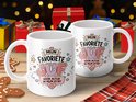 Twee witte mokken met de tekst "MIJN FAVORIETE JUF VOOR ALTIJD IN MIJN HORT" in kleurrijke letters, versierd met hartjes en sterren. Op de achtergrond cadeaus en kerstversiering.