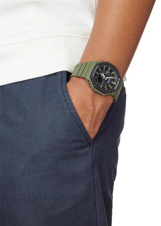 Groen G-Shock horloge met zwarte wijzerplaat op pols.