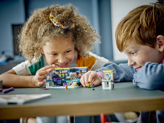 Twee kinderen kijken naar en spelen met een LEGO Friends speelset.