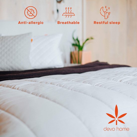 Close-up van een wit hennep zomerdekbed met iconen voor anti-allergie, ademend en rustgevende slaap. Logo 'devo home'.