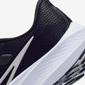 Detail van zwarte Nike hardloopschoen met witte swoosh en witte zoolrand.