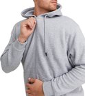 Man met lichtgrijze hoodie, rits gedeeltelijk geopend, grijze broek.