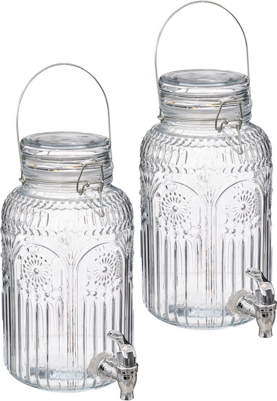 Twee glazen drankdispensers met bewerkt deco glas en zilverkleurige tapkranen.