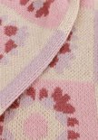 Detail van lila gebreide stof met bloemenpatroon in roze en beige.
