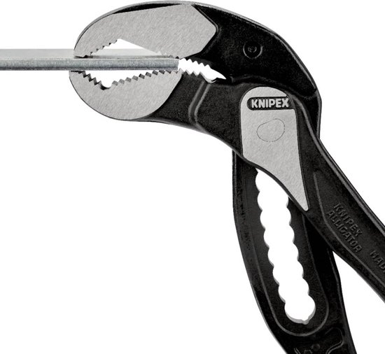 Gedetailleerde opname van de bek van een Knipex Alligator tang die een metalen staaf klemt.