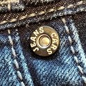 Knop met "CARS JEANS" op een donkerblauwe spijkerbroek.