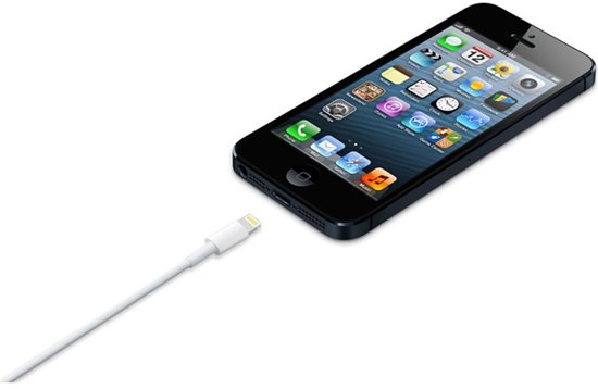 Witte Apple Lightning kabel aangesloten op een zwarte iPhone.