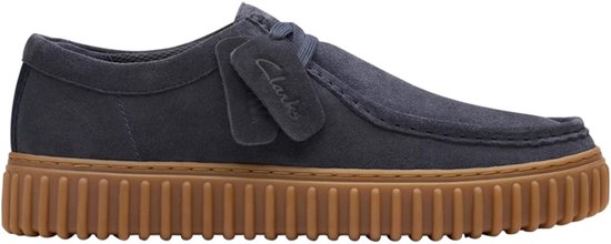 Donkerblauwe suède schoen met veters, bruine rubberen zool en Clarks-label aan de zijkant.