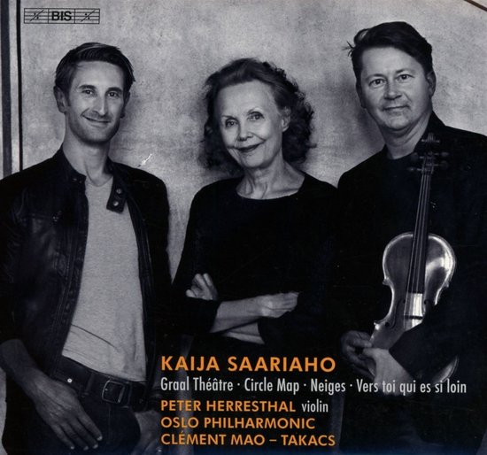 Drie musici staan met een glimlach op de foto: twee mannen en een vrouw. De man rechts houdt een viool vast. Boven hen staat de tekst 'KAIIA SAARIAHO'.
