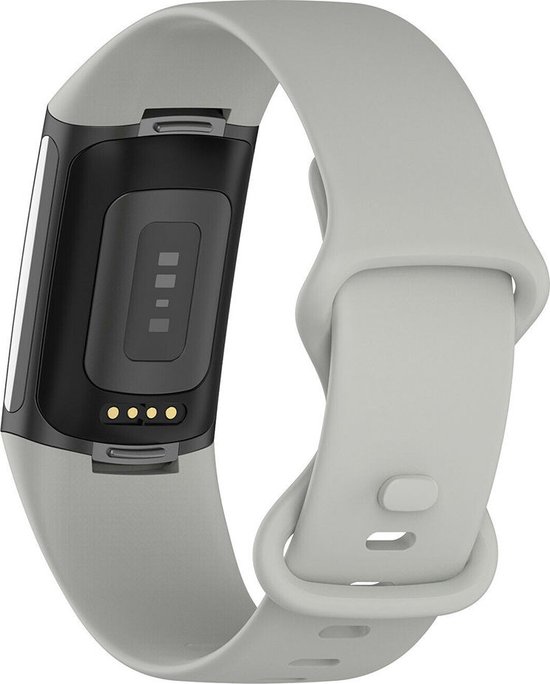 Achterkant van een grijze siliconen Fitbit Charge 5 horlogeband met hartslagsensor en oplaadpunten.