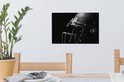 Un casque de football américain noir avec masque en acier, sur un mur à côté d'une plante.