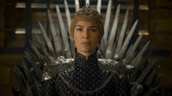 Cersei Lannister met blonde paardenstaart en kroon, zittend op de IJzeren Troon.