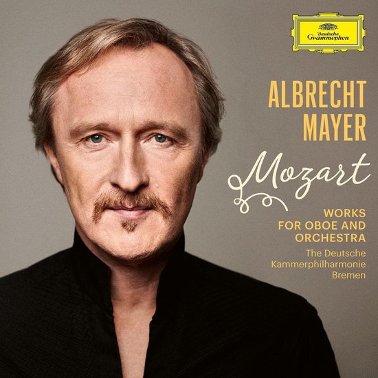 Close-up portret van Albrecht Mayer met snor en sik, gekleed in een zwart shirt.