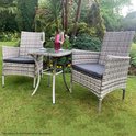Grijze rotan stoelen en tafel in een tuinsetting, met fles en glazen.