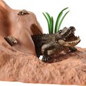 Close-up van speelgoed: krokodil met bek open op rots met schildpadden.