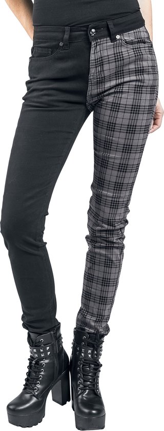 Model draagt een broek die aan de linkerzijde zwart is en aan de rechterzijde een grijze ruit heeft. Zwarte enkellaarsjes met plateauzool.