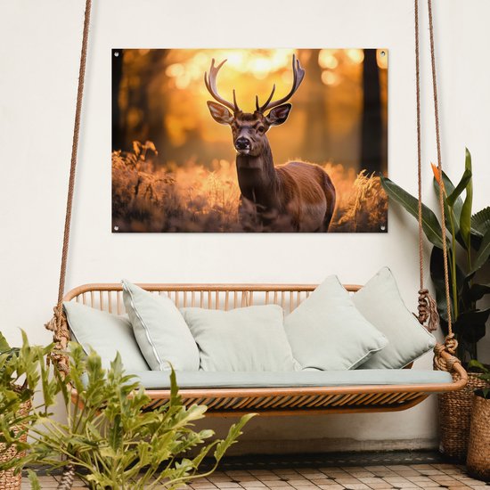 Een tuinposter met een hert in een bos hangt boven een schommelbank op een terras.