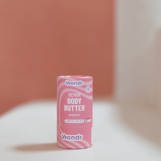 Beurre corporel réparateur Wondr abricot sur un emballage rayé rose et blanc. Convient aux peaux sensibles et sèches.