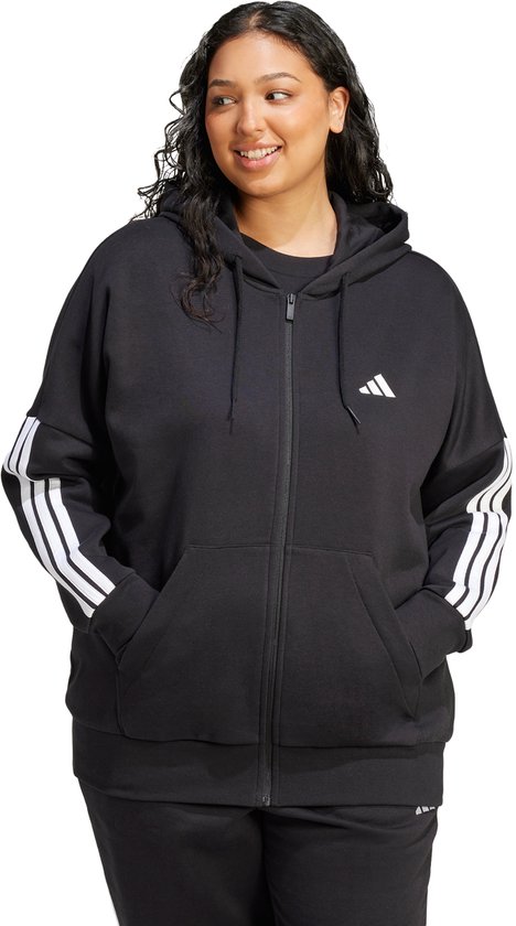 Vrouw draagt een zwarte hoodie met ritssluiting, witte Adidas logo op borst en mouwen, met strepen op de mouwen.