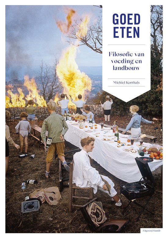 Boekomslag 'Goed eten' met kinderen rond een gedekte tafel en brandende heuvels op achtergrond.