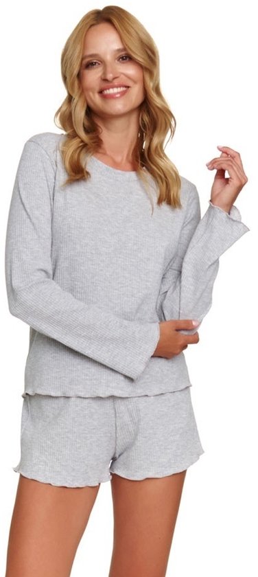 Een vrouw met blond haar in een lichtgrijze pyjamaset van geribd materiaal, met lange mouwen en een short, op witte achtergrond.