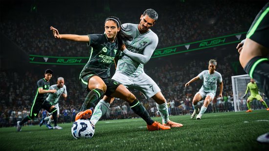 Vrouwelijke footballspeler in donkergroen tenue verdedigt tegen een mannelijke keeper in lichtgrijs tenue.