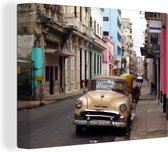 Canvas Schilderij Een Cubaanse oldtimer staat in een klein straatje in Oud Havana - 40x30 cm - Wanddecoratie