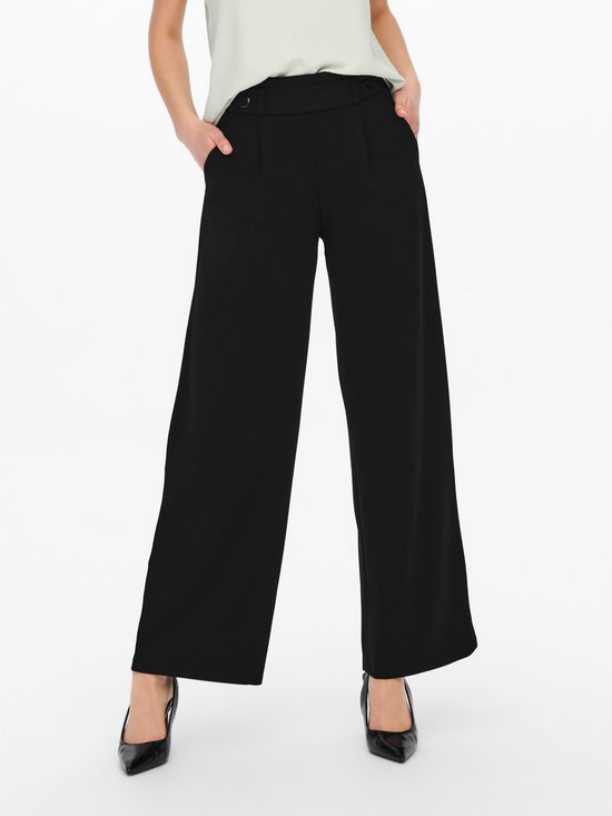 Model draagt zwarte wijde broek met hoge taille en knoopdetails.