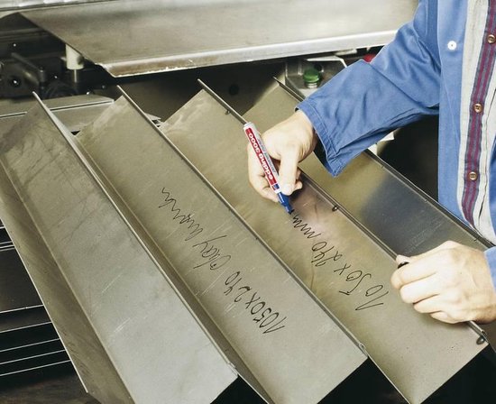 Een hand met een blauwe Edding marker schrijft op metalen platen met tekst.