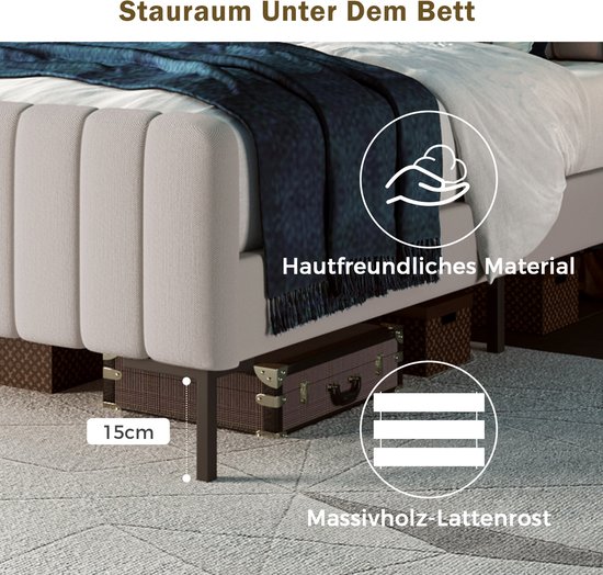 Détail du côté d'un lit rembourré beige clair avec un tissu rayé, une couverture bleu foncé et un rangement sous le lit.