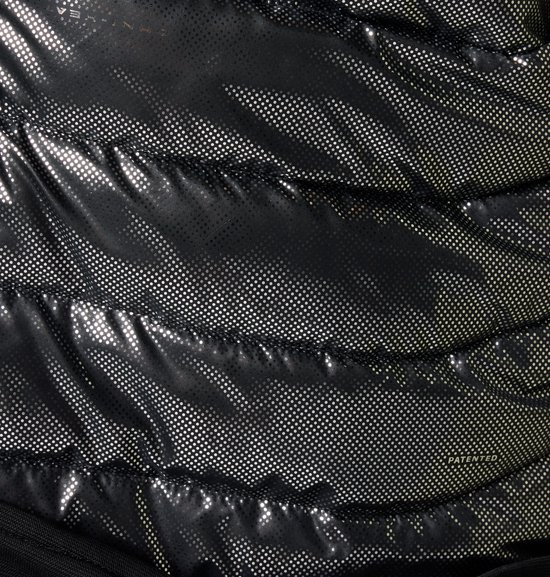 Detail van de reflecterende zilveren voering van een zwarte Columbia jas met een stippenpatroon.