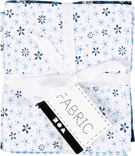 Stapel witte stof met kleine blauwe bloemetjes, vastgebonden met wit lint en een label.
