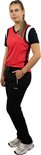 Vrouw in zwarte trainingsbroek en rode sporttop met marineblauwe mouwen, zijaanzicht.