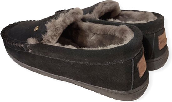 Zwarte suède pantoffels met grijze voering en bruine label op de hak.