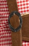 Détail de la boucle métallique sur la bretelle de la culotte de leder brune.